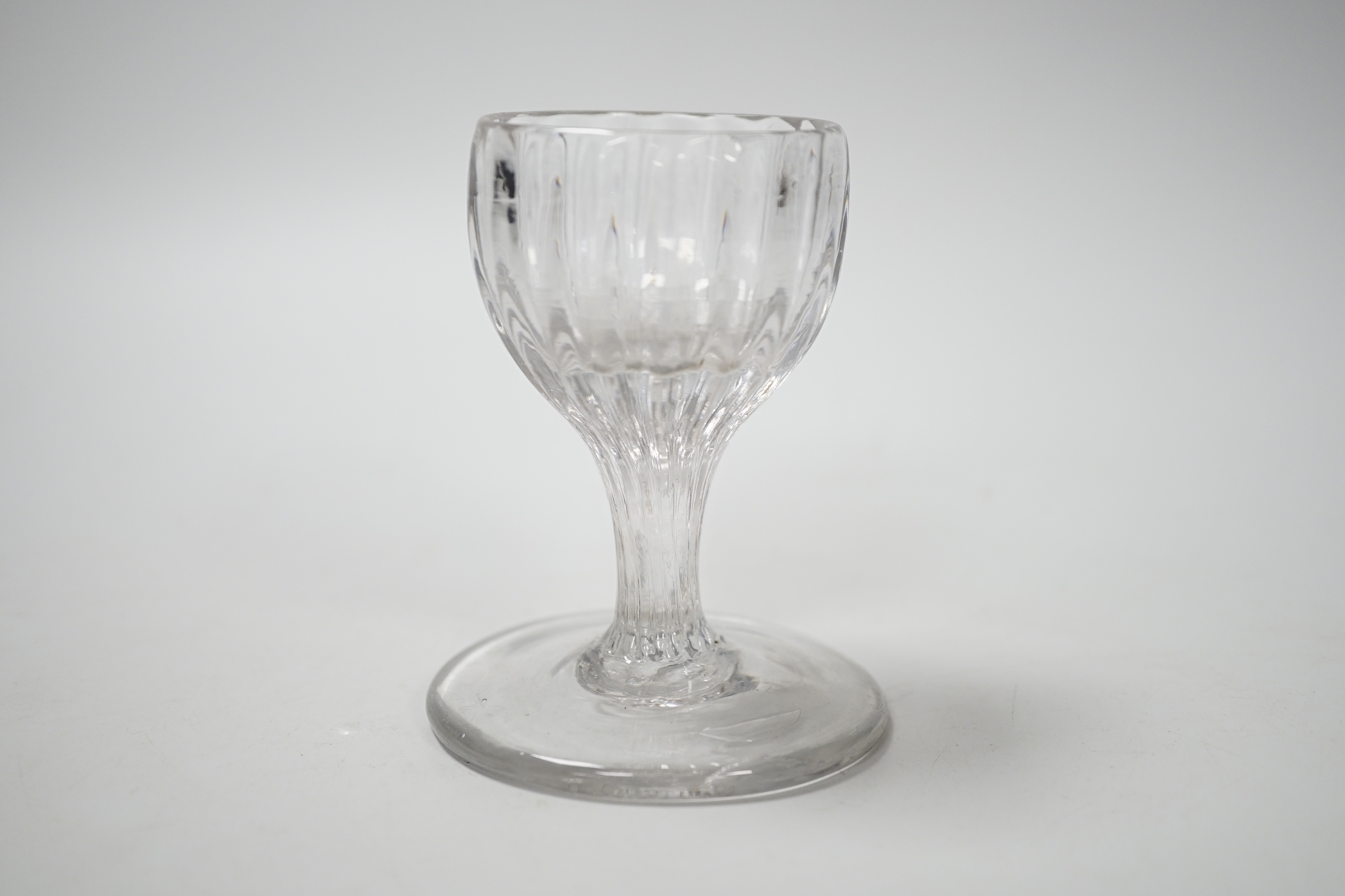 An English lead crystal dram, mid 18th century, with rib moulded bowl / stem, this rare drawn trumpet and moulded form sitting on a wide base, possibly for use on board ship, 9.5cm high